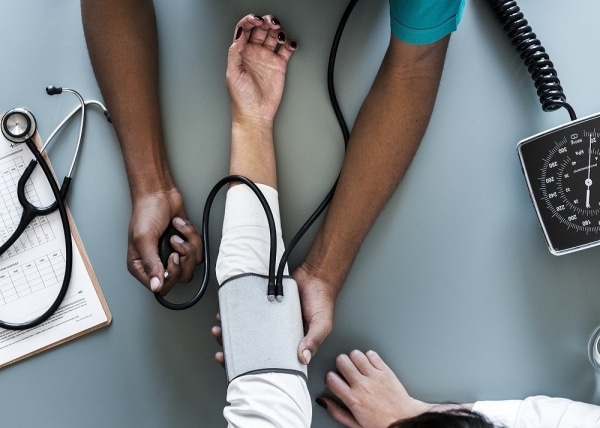 Doctor taking patient's blood pressure - Newcastle Research Institute - Genesis Research Services