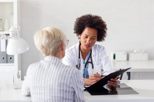 Clinical trial participant with study doctor showing research results